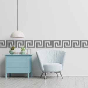 Peut inclure: Int&eacute;rieur moderne avec une commode bleu clair, un fauteuil blanc et une bordure grecque grise sur le mur. Un luminaire suspendu blanc est suspendu au-dessus de la commode, et de petites plantes en pot ajoutent de la verdure.