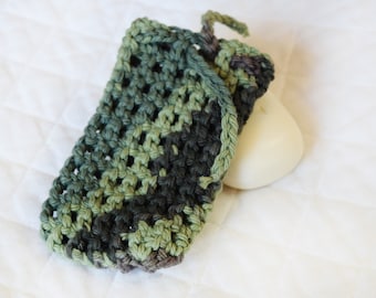 May include: A green, black and brown crocheted soap saver with a white bar of soap inside.