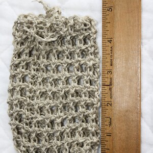 May include: A beige, crocheted, mesh bag with a drawstring closure. The bag is about 4 inches tall and 2 inches wide.