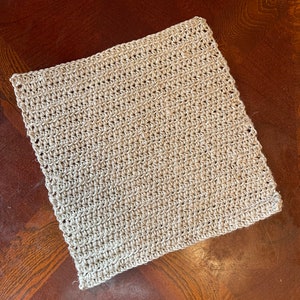 May include: A beige crocheted square dishcloth or kitchen scrubber.