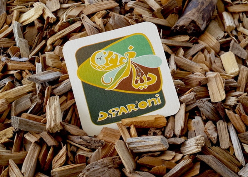 May include: A brown and green square coaster with a stylized bee design and the text "D.FARONI" in yellow letters.