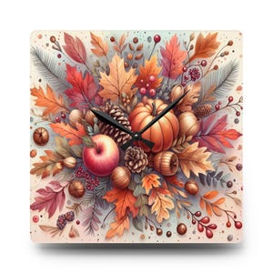 Puede incluir: Reloj de pared cuadrado con diseño otoñal. La obra de arte incluye una calabaza, una manzana roja, bellotas, piñas y hojas de otoño coloridas en tonos naranja, rojo y marrón. Las manecillas negras indican la hora. Un elemento decorativo para el hogar.