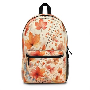 May include: A beige backpack with a watercolor print of orange and red maple leaves and berries.