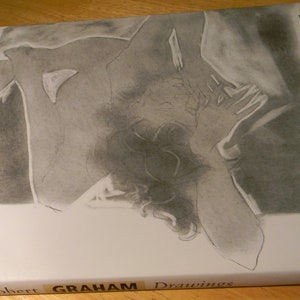 May include: A black and white drawing of a nude figure on the cover of a book titled "Robert GRAHAM Drawings" with the author's name "NEUEINDORF" on the spine.