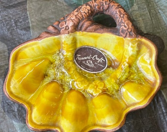 Könnte beinhalten: Eine gelbe Keramikschale mit einem braunen Griff und einem Blumendesign. Die Schale hat sechs Abschnitte und ist mit "Treasure-Craft of Hawaii, Maui, Hawaii" beschriftet.