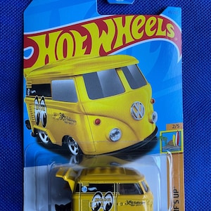 May include: A yellow Hot Wheels die-cast toy car, a Volkswagen van with a "Moon Eyes" graphic and "36th Anniversary 1969-2005" text. The car is on a blue and white card with the words "Hot Wheels" and "Surf's Up" printed on it.