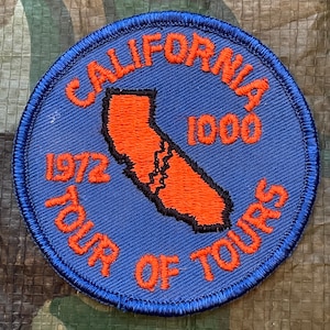 May include: A blue and orange embroidered patch with the text "California Tour of Tours 1972 1000" and an outline of the state of California.
