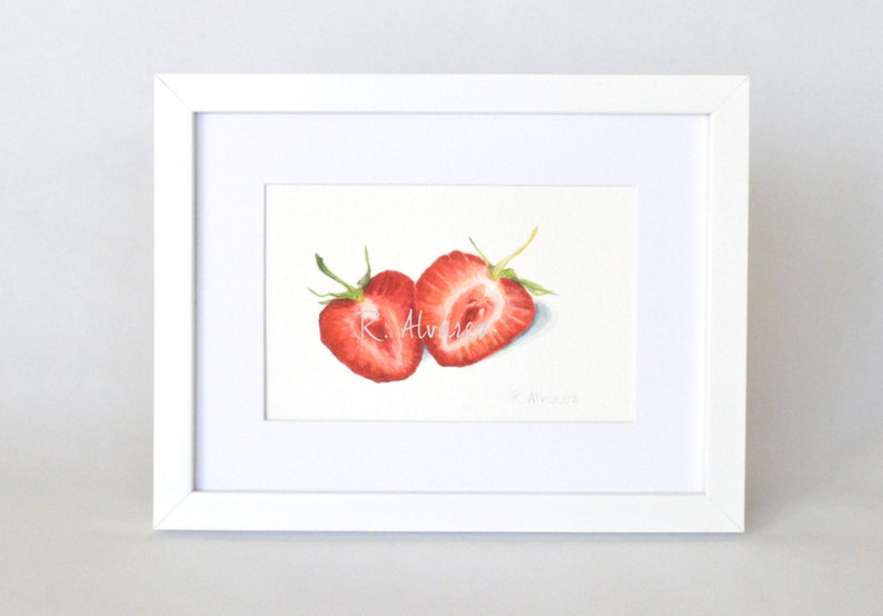 Op de afbeelding: Een aquarel schilderij van twee gehalveerde aardbeien, een met de zaadjes naar de kijker toe en de andere met de zaadjes naar achteren. De aardbeien zijn felrood en het schilderij is gesigneerd met "R. Alvarez".