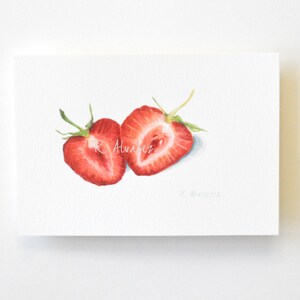 Op de afbeelding: Waterverf schilderij van twee gehalveerde aardbeien, geschilderd in tinten rood en groen. De aardbeien zijn op een witte achtergrond met de handtekening van de kunstenaar rechtsonder.