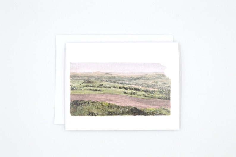 May include: Watercolour painting of a landscape with rolling hills and fields. The painting is done in shades of green, brown, and grey.