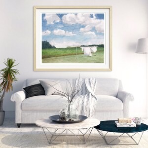 May include: A framed watercolor painting of a green field with white laundry hanging on a clothesline. The sky is blue with white clouds.