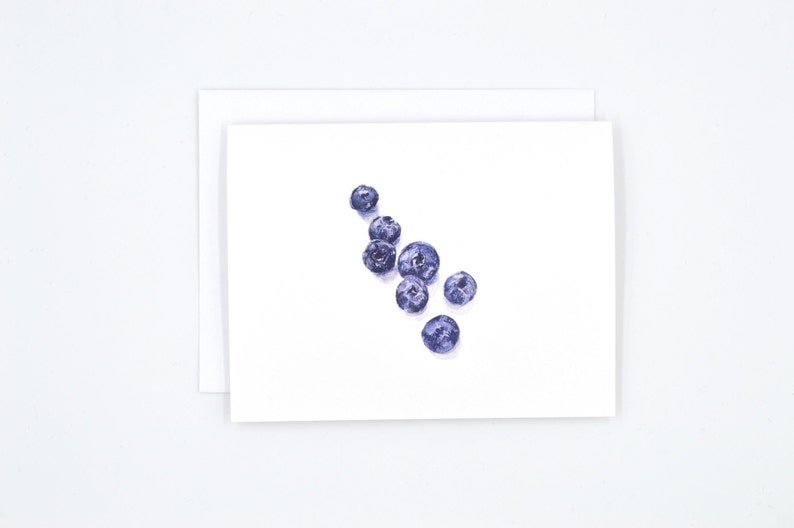 May include: A watercolour painting of blueberries on a white background. The blueberries are arranged in a loose cluster, with some overlapping.