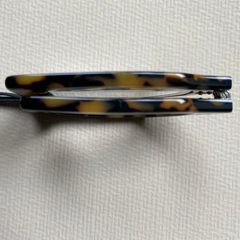 May include: A pair of tortoiseshell eyeglasses with a spring hinge.