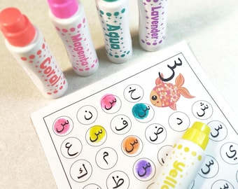May include: A set of colorful markers with the words "Coral", "Magenta", "Aqua", and "Lavender" written on them. The markers are used to color in a worksheet with Arabic letters and a picture of a fish. The worksheet has the word "س" written at the top.