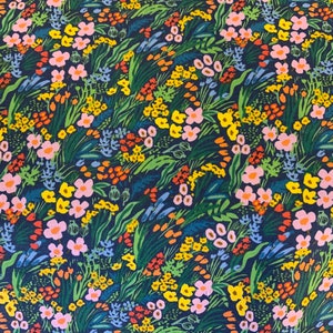 May include: A dark blue fabric with a floral pattern. The pattern features pink, yellow, orange, and green flowers on a dark blue background.