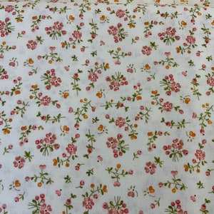 Puede incluir: Tela blanca con un estampado floral a pequeña escala. Las flores son rosas y los tallos son verdes. También hay pequeños puntos naranjas dispersos por toda la tela.