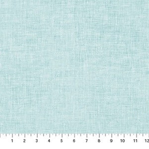 Op de afbeelding: Close-up van een lichtblauwe stof met een getextureerde weefsel. Een liniaal aan de onderkant toont metingen in inches, wat overeenkomt met ongeveer 2,5 tot 30,5 cm.