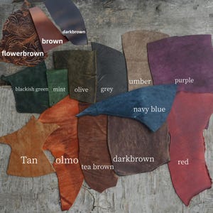 Puede incluir: Muestras de cuero en varios colores, incluyendo marr&oacute;n, tostado, rojo, morado, azul marino, gris, oliva, menta y verde. Las muestras est&aacute;n dispuestas en un semic&iacute;rculo sobre una superficie de madera.