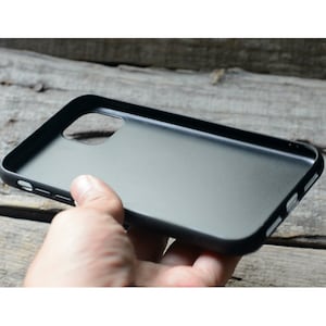 May include: A black phone case with a cutout for the camera lens.