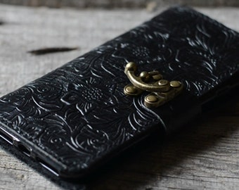 May include: Black leather phone case with a floral embossed design and a gold-toned clasp.