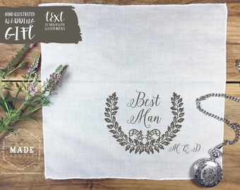 May include: A white square handkerchief featuring a dark grey printed design of a laurel wreath surrounding the text "Best Man" and the initials "M. Q. D." below. A silver pocket watch with a chain is placed on the bottom right corner.