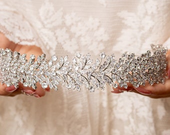 May include: A silver tiara with a delicate design of leaves and sparkling rhinestones.