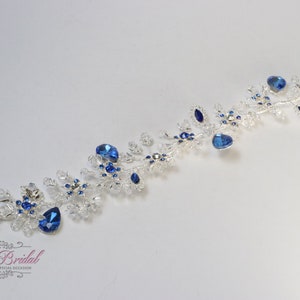 May include: Silver hair comb with blue crystal embellishments. The comb has two prongs for easy placement in hair.