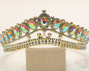 May include: A gold crown with iridescent stones. The crown has a double row of smaller stones around the base.