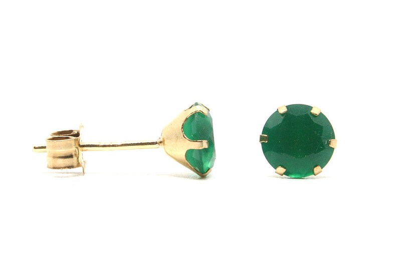 Puede incluir: Un par de pendientes de oro con piedras preciosas verdes.