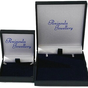 Może przedstawiać: Dwa czarne pudełka na biżuterię z szarym wnętrzem i niebieskim tekstem "Peninsula Jewellery".