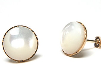 May include: A pair of gold earrings with white mother of pearl round stones set in a gold bezel.