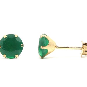 Puede incluir: Un par de pendientes de oro con piedras preciosas verdes.