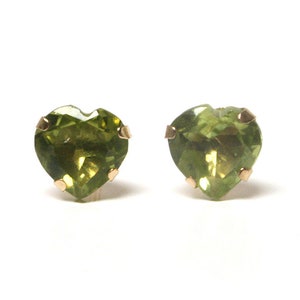 May include: A pair of heart-shaped green peridot earrings with gold settings.