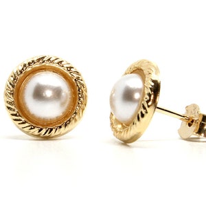 May include: A pair of gold-tone pearl stud earrings. Each earring features a round, white pearl set in a gold-tone bezel with a rope-like design around the edge.