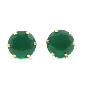 Puede incluir: Un par de pendientes de oro con piedras preciosas verdes.