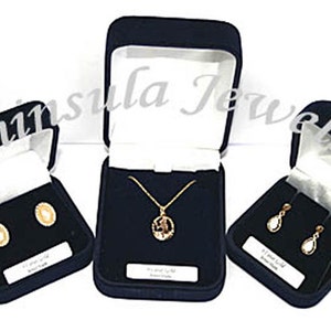 May include: Three black velvet jewelry boxes with white interior lining. The boxes contain gold earrings, a gold necklace with a pendant, and gold dangle earrings.