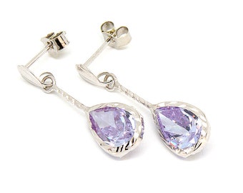 Puede incluir: Un par de pendientes de plata con piedras preciosas de color púrpura en forma de pera.