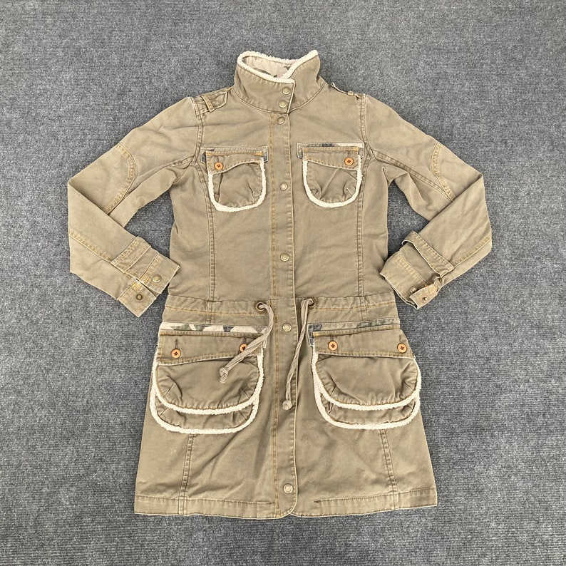 May include: A long-sleeved, brown, utility-style jacket with a faux fur collar and multiple pockets. The jacket has a drawstring waist and a button-up front.