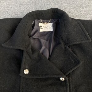 May include: Black wool coat with a notched collar and silver-tone buttons. The coat features a double-breasted design and a label that reads "Courr&egrave;ges Paris". The coat is a classic outerwear piece.