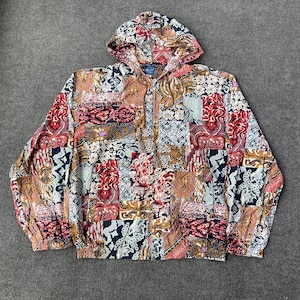 May include: A multi-colored hooded jacket with a patchwork design featuring various floral and geometric patterns. The jacket has a zipper closure and a drawstring hood.