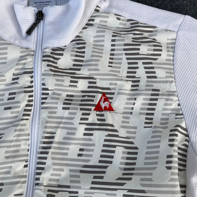 May include: White zippered jacket with a gray and white striped pattern and a red rooster logo on the left chest.