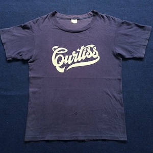 May include: A vintage navy blue t-shirt with a white "Curtiss" logo printed on the front.