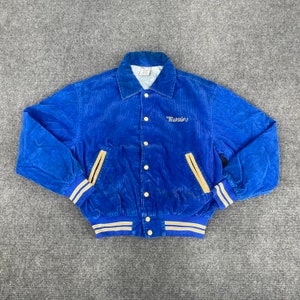 Puede incluir: Una chaqueta de béisbol de pana azul con ribetes de rayas doradas y azules. La chaqueta tiene cierre de botones y un pequeño logotipo bordado que dice "Maruim".