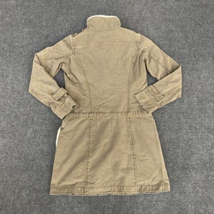 May include: A brown long-sleeved jacket with a faux fur collar and a drawstring waist.