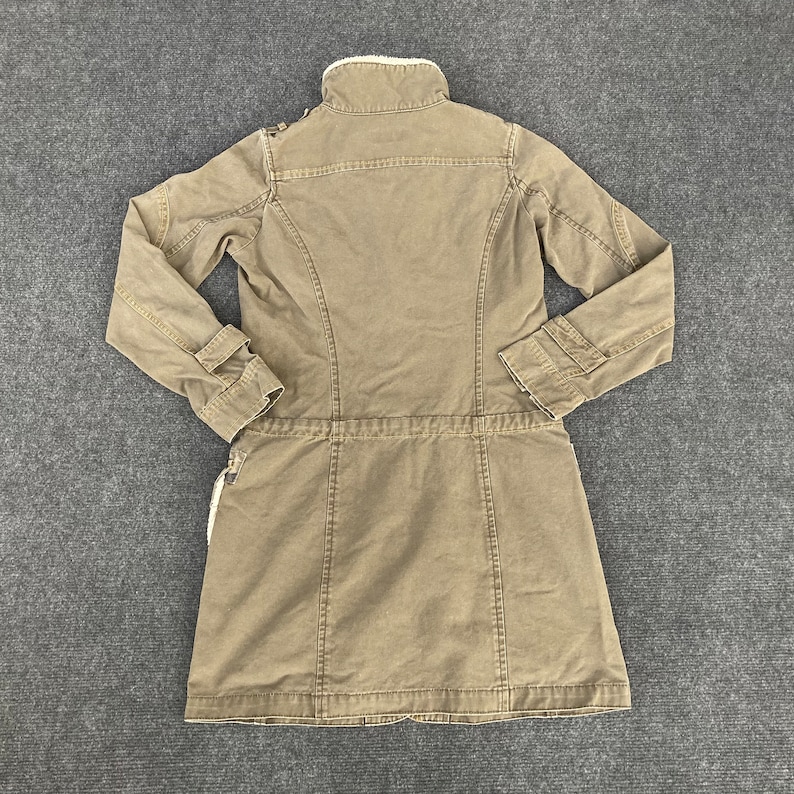 May include: A brown long-sleeved jacket with a faux fur collar and a drawstring waist.