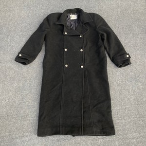 May include: A black wool coat with a double-breasted design. The coat features a notched collar, long sleeves with buttoned cuffs, and decorative silver-colored buttons. The coat is approximately 48 inches long.