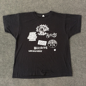 May include: Black t-shirt with white print featuring the text "Anti-Nowhere League" and "The Adicts", along with other band logos and the text "Blitz Krieg Locals Only".