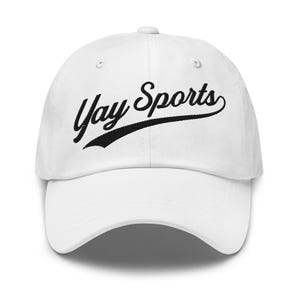 May include: A white baseball cap with the words "Yay Sports" embroidered in black script. The hat has a curved peak and an adjustable strap. A classic accessory for sports fans.