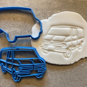 May include: Blue plastic cookie cutter in the shape of a van. The cutter is shown next to a white impression of the van in modeling clay.