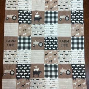 May include: A patchwork fabric panel with a farm theme. The panel features a variety of farm animals, including cows, pigs, horses, and chickens. The panel also features tractors, farmhouses, and other farm-related imagery. The panel is made of a variety of fabrics, including cotton, linen, and burlap. The panel is perfect for quilting, crafting, and home decor.
